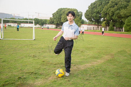 学生比赛摄影照片_球场踢球运动帅哥学生摄影图配图