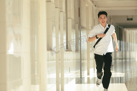 小茗同学摄影照片_阳光男生学生走廊奔跑摄影图配图