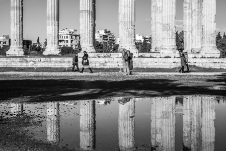 行人摄影照片_雨后阿波罗神庙的倒影与行人摄影图