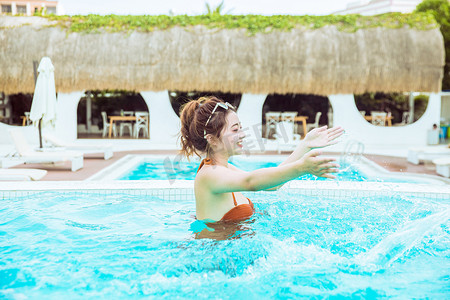 比基尼美女写真摄影照片_夏日清凉白天比基尼美女泳池玩水摄影图配图