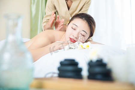 按摩养生白天spa养生的美女和技师按摩床趴着摄影图配图