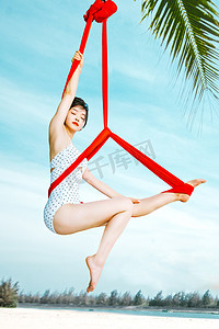 泳衣美女摄影照片_空中瑜伽白天瑜伽美女教练户外椰林空中瑜伽体式摄影图配图
