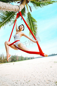 空中瑜伽白天比基尼美女户外沙滩空中瑜伽体式摄影图配图