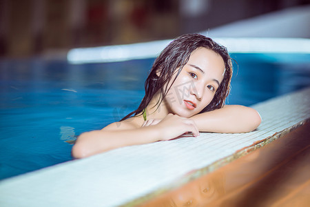 夏天泳池美女晚上比基尼美女户外泳池趴在泳池边摄影图配图