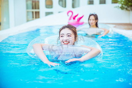 清新美女人像摄影照片_夏日清凉白天在游泳圈里的美女泳池游泳摄影图配图