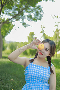 夏季休闲白天美女野外手拿水果摄影图配图