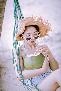 人物形象夏天美女沙滩喝椰子汁摄影图配图