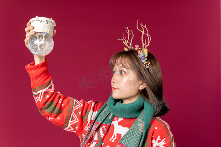 圣诞节球水晶球摄影照片_圣诞节创意圣诞装扮女性手拿水晶球倒挂