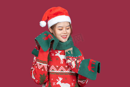 圣诞围巾摄影照片_圣诞节创意圣诞装扮女性棚拍玩围巾