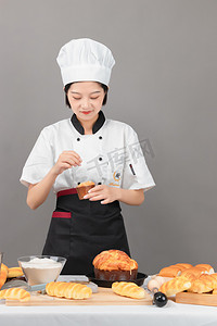 厨厨师帽通摄影照片_做面包白天女孩室内烘培摄影图配图