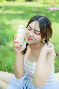 大暑小暑白天女孩公园喝酸奶摄影图配图