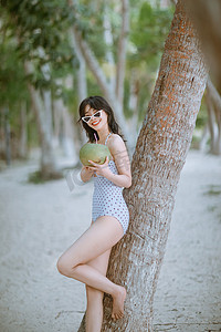 人物形象夏天午后美女椰树林手拿椰子摄影图配图
