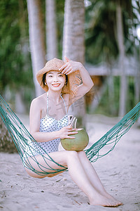 人物白天美女沙滩手拿帽子摄影图配图