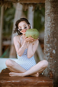 人物夏天美女椰树林手托椰子摄影图配图