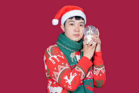 圣诞节球水晶球摄影照片_青年男子穿圣诞服手拿水晶球