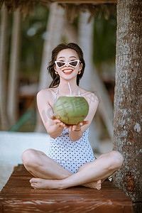 人物夏天美女椰树林手拿椰子摄影图配图