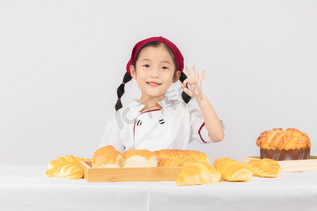 儿童辅食面包摄影照片_儿童早上女孩室内烘焙厨师摄影图配图