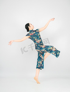 舞台炫酷光摄影照片_旗袍舞者白天美女舞台起舞摄影图配图