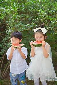 夏季玩耍女孩摄影照片_夏季白天小朋友西瓜户外男孩女孩摄影图配图