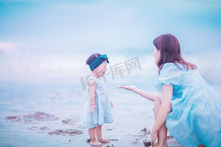两个女孩手环摄影照片_亲子时光白天母女两个户外沙滩玩耍摄影图配图