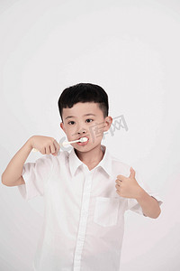 小孩刷牙摄影照片_刷牙白天男孩室内清洁讲卫生摄影图配图