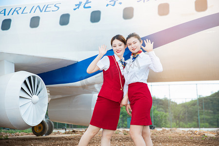 空乘白天两位女乘务员机舱外招手摄影图配图