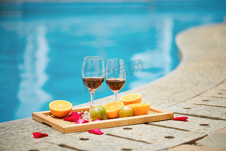 夏天度假白天放着红酒和水果的托盘泳池无摄影图配图