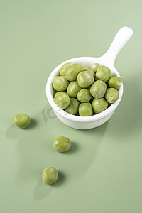绿豆植物摄影照片_绿色新鲜豌豆洒落特写摄影图配图