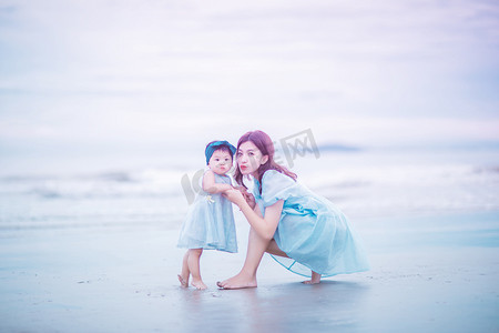 在一起摄影照片_亲子时光白天母女两个户外沙滩依偎在一起摄影图配图