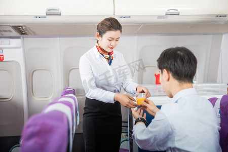 客舱服务白天男旅客和空姐客舱内递饮料摄影图配图