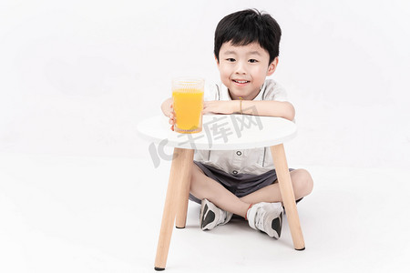 美食橙汁摄影照片_夏季白天男孩手拿橙汁摄影图配图
