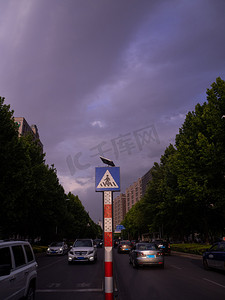 暴雨摄影照片_城市风光傍晚街道马路上行驶的车摄影图配图