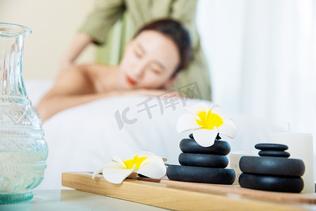 理疗养生白天按摩美女按摩床上趴着摄影图配图