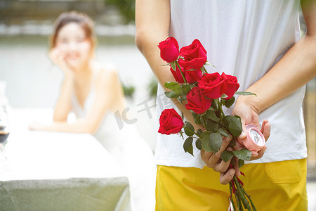 帅哥摄影照片_爱情求婚白天准备求婚的帅哥户外藏起玫瑰花和戒指摄影图配图