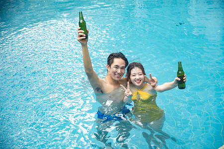 人物形象夏天情侣泳池举瓶摄影图配图