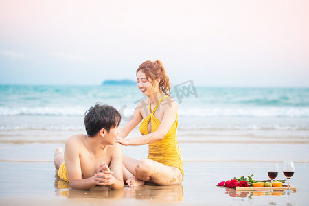 爱情白天一对情侣沙滩按摩背部擦防晒摄影图配图