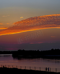 黄色晚霞摄影照片_夏天天边风光夕阳天空晚霞户外飘动的云彩摄影图配图