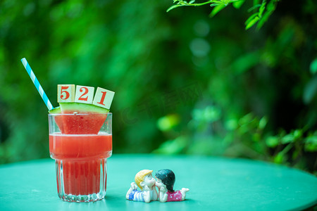 清凉夏日摄影照片_夏日饮品白天西瓜汁树阴下的桌子文艺唯美背景摄影图配图