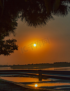 夏天自然风光夕阳光照反射在水面上户外海边夕阳西下摄影图配图