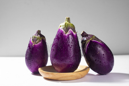 新鲜蔬果摄影照片_静物蔬菜三个茄子紫色茄子新鲜茄子摄影图配图