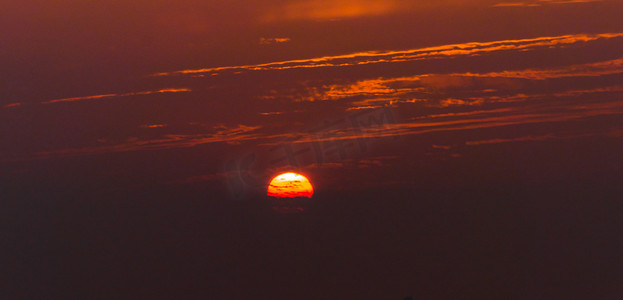 黄色晚霞摄影照片_夏天自然风光傍晚夕阳光照户外天空太阳躲进云层摄影图配图