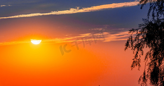 夏天日落风光夕阳太阳户外天空太阳漏出云层摄影图配图