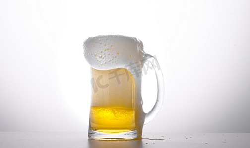 透明黄色摄影照片_夏天泡沫饮料白昼一杯啤酒室内静物摆拍摄影图配图