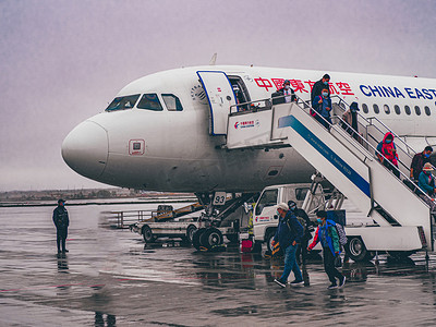 敦煌机场雨中下飞机的人飞机场下机摄影图配图