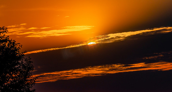 太阳橙色摄影照片_夏天日落风光傍晚夕阳户外天空太阳缓缓落下摄影图配图