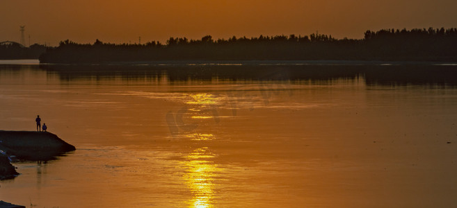 夏天风光夕阳两个人户外湖畔边看日落摄影图配图
