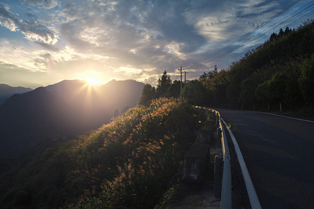 山顶山脉摄影照片_山上的公路日落公路山里无摄影图配图