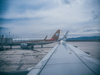 飞机机翼摄影照片_飞机场白天飞机机翼广场上等待起飞摄影图配图
