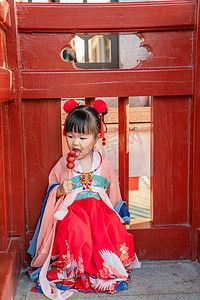 小串糖葫芦摄影照片_吃糖葫芦夕阳儿童室外吃摄影图配图