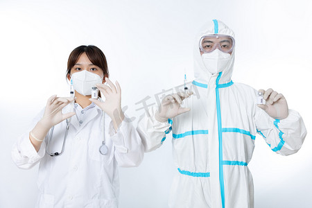 防疫抗疫双人医护人员棚拍手拿疫苗和注射器摄影图配图